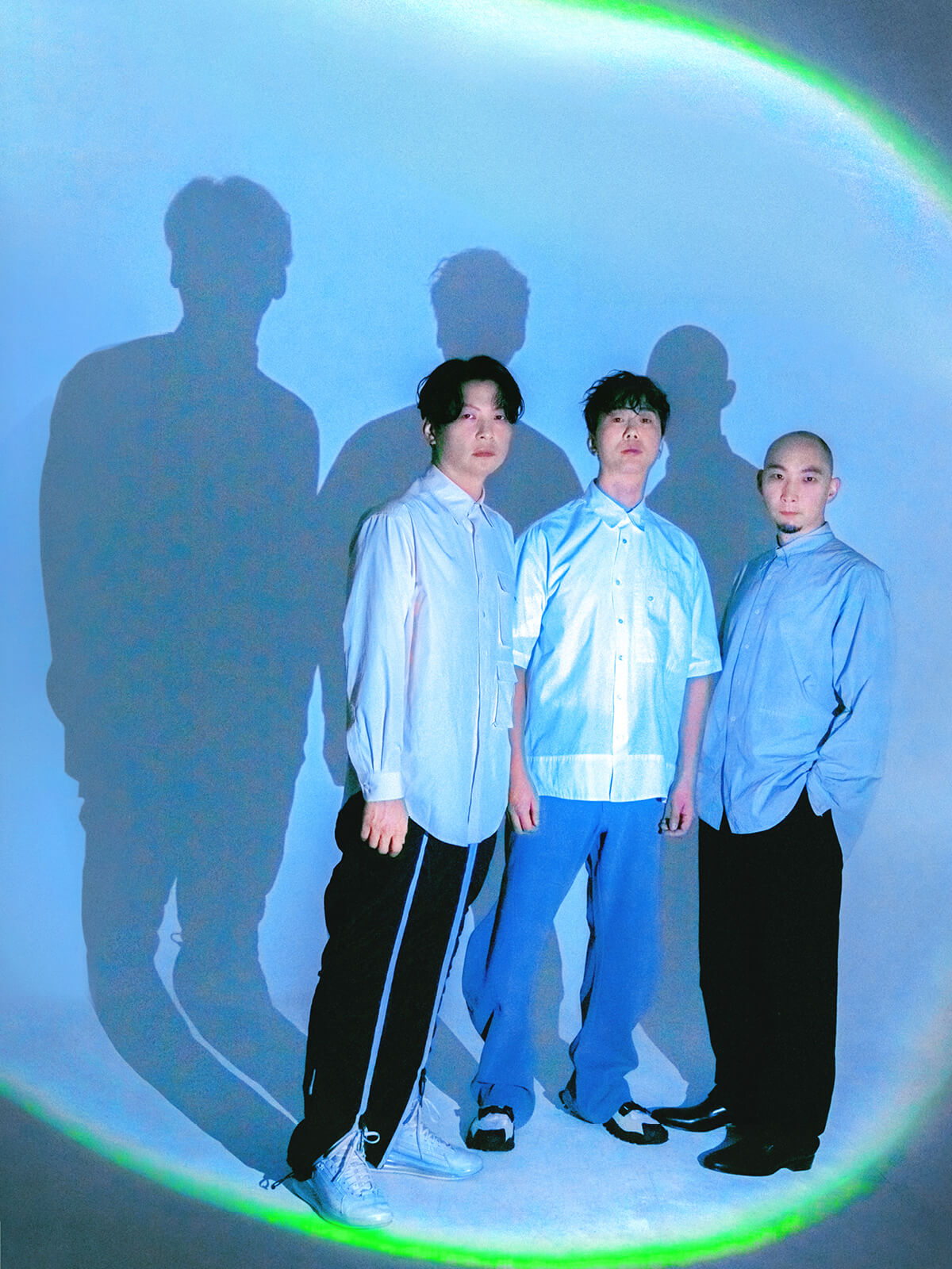 Drei Männer stehen vor einem hellblauen Hintergrund